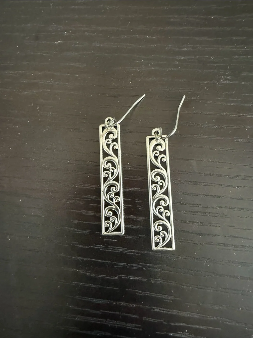Silver-toned rectangular earrings with ornate scrollwork design